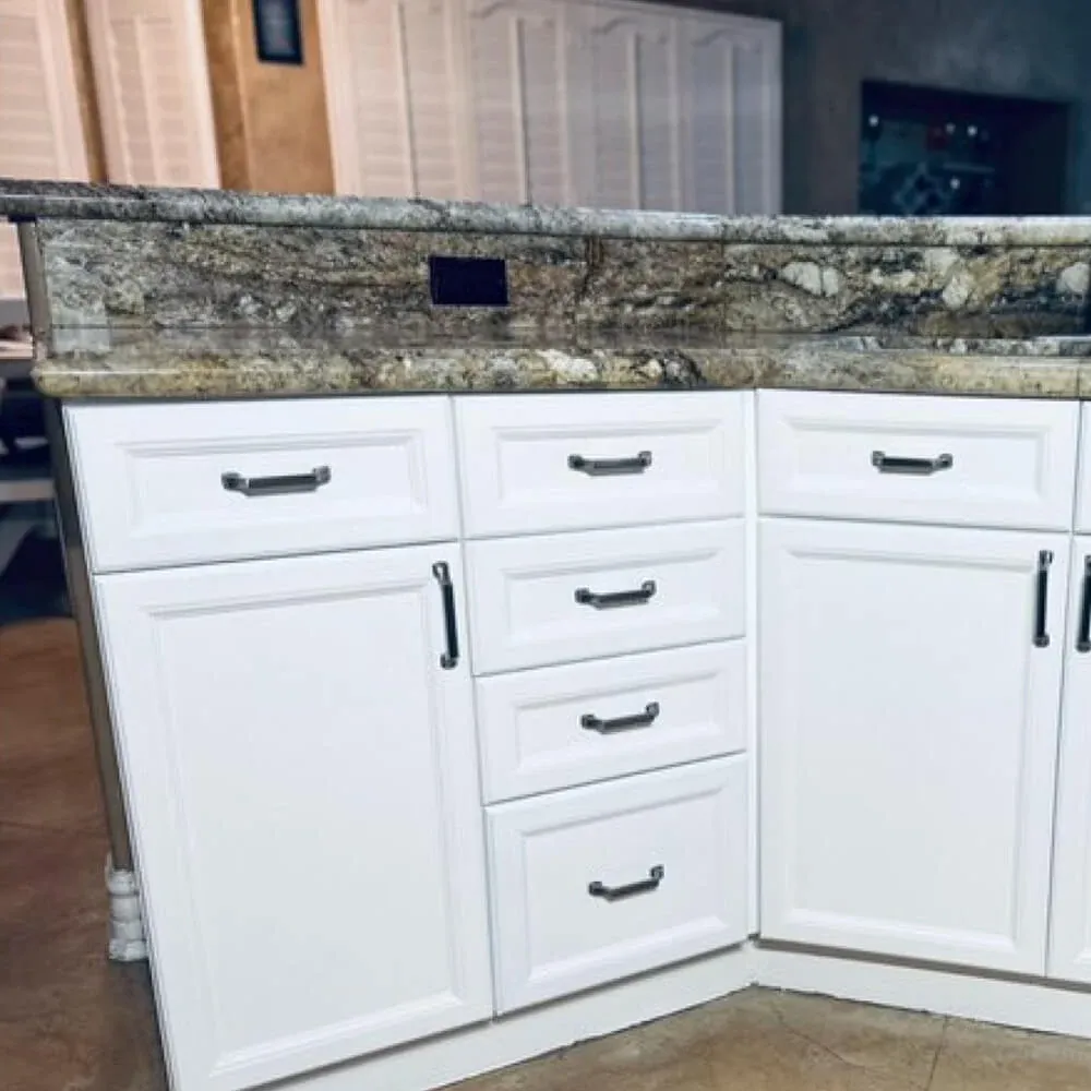Kitchen cabinets refinished in white with new pull hardware below a granite countertop