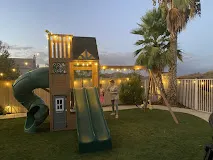 Backyard play structure assembled with landscape string lighting installed
