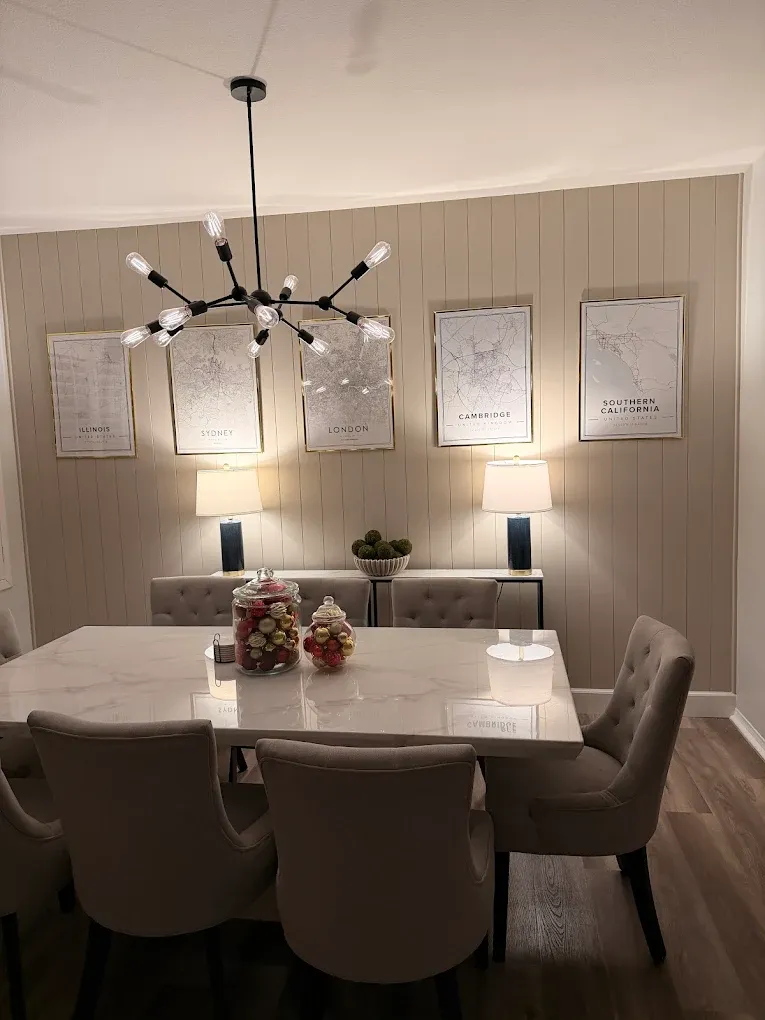 Dining room with new vertical shiplap accent wall, modern chandelier, and framed gallery wall