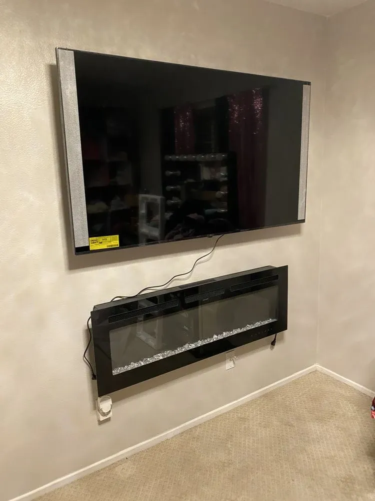 Wall-mounted TV installed above a recessed electric fireplace